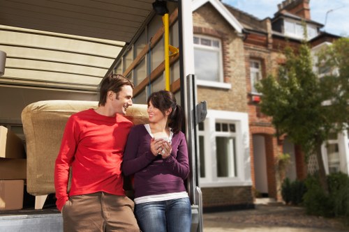 Movers handling furniture and boxes in a Shoreditch flat building